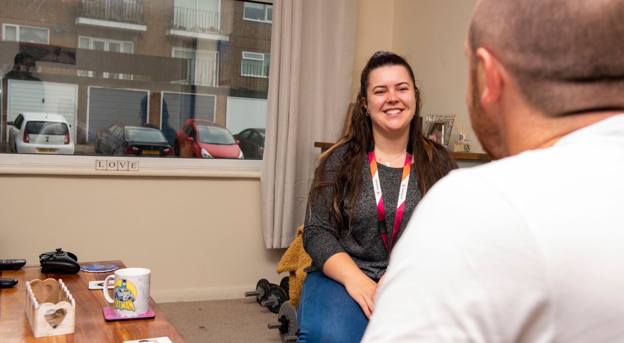 Support worker smiling while meeting with a resident in their home.