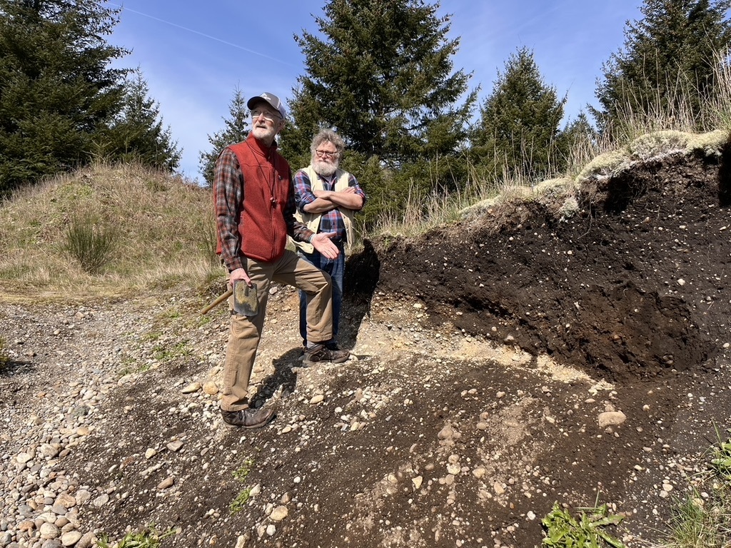 Knute Berger and a geologist stand on a hillside