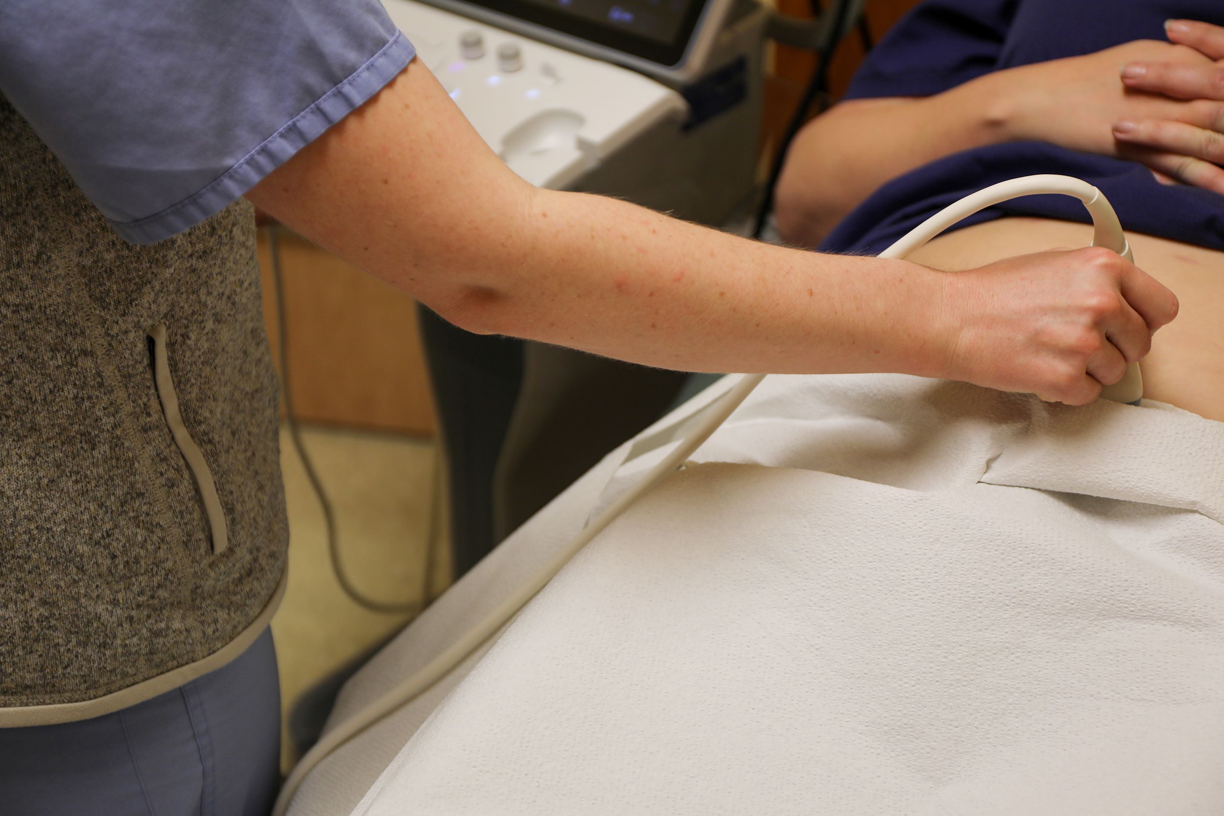 A nurse administers and ultrasound to a pregnant person.