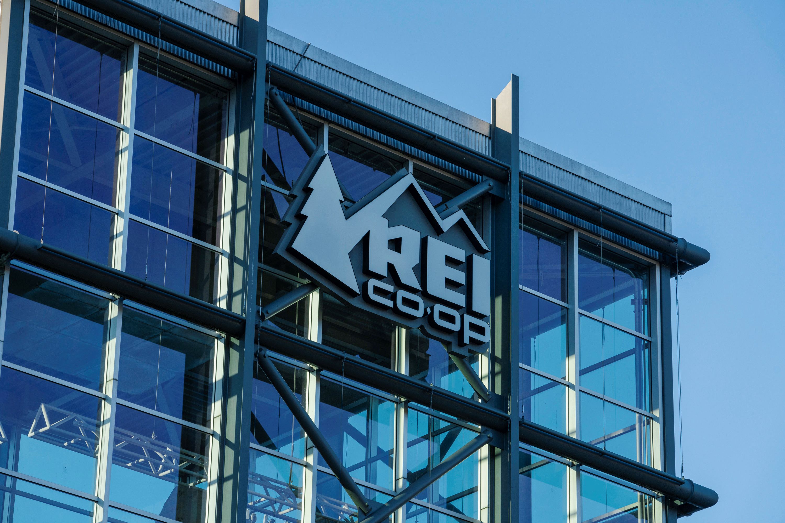 A glass-fronted building with the REI logo on it