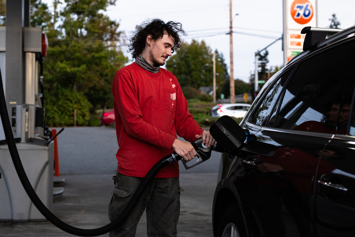 A young person pumps gas
