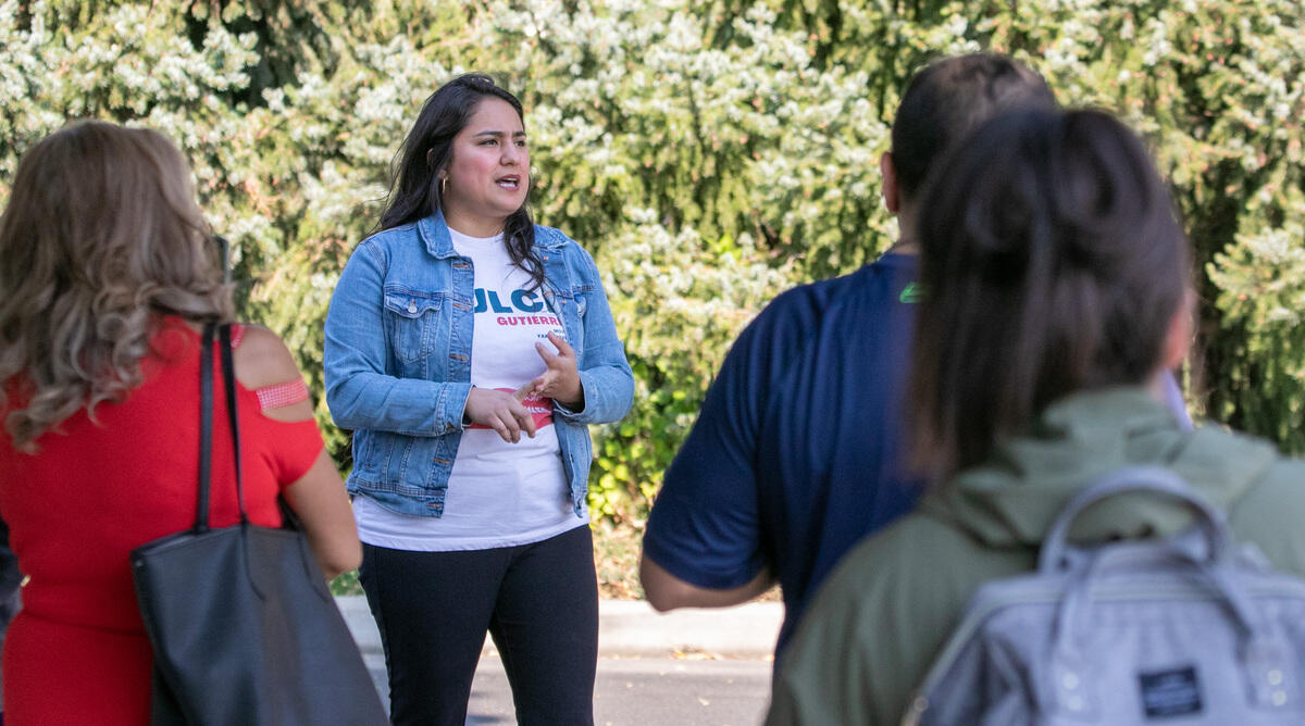 A candidate speaks to a gathered crowd of people.