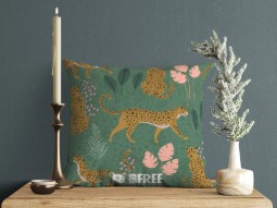 A photo of a green cushion featuring illustrations of leopards and flowers