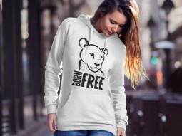 A photo of a woman walking down the street wearing a white hoodie with a large print of the Born Free logo featuring 'Elsa the lioness' 