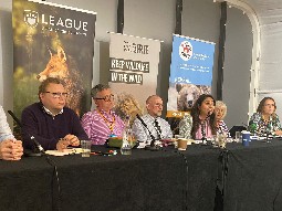A photo of a panel of people sitting at a conference with a Born Free banner in the background