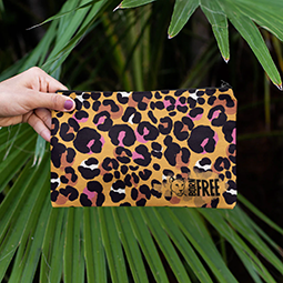 A pencil case with leopard print being held up against leafy background