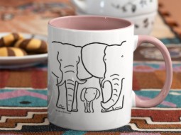 A photo of a while ceramic mug with pale pink handle and interior, featuring a black line-drawing of a family of elephants