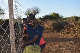 Two men working on constructing a wire fence