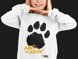 A photo of a young girl wearing a white sweatshirt with a large back paw print on and words 'PART OF THE PRIDE!'