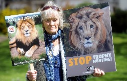 Dame Virginia McKenna holding up two placards which call for an end to trophy hunting