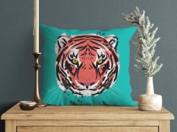 A photo of a teal-coloured cushion featuring a brighly coloured illustration of a tiger's face