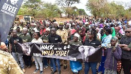 A large group of people gathered together for a march, holding Born Free banners