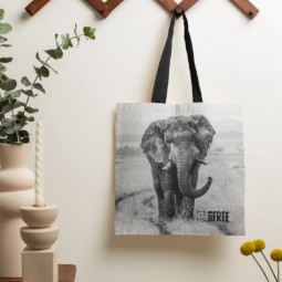 A tote bag featuring a black and white image of an elephant in the wild