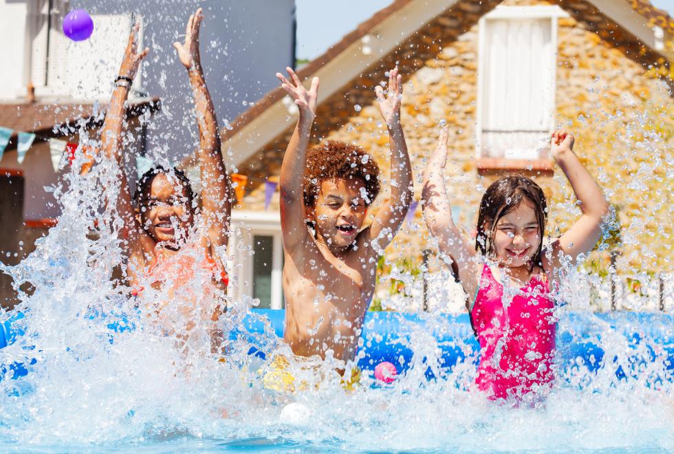 Kids playing in a backyard pool.