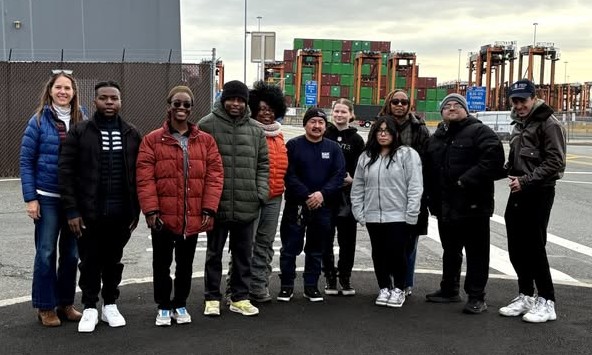 A dozen advocates standing by an industrial port in New Jersey